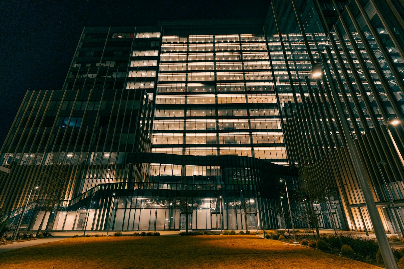 Kantoorgebouw met verlichte ramen en toegangen bij nacht